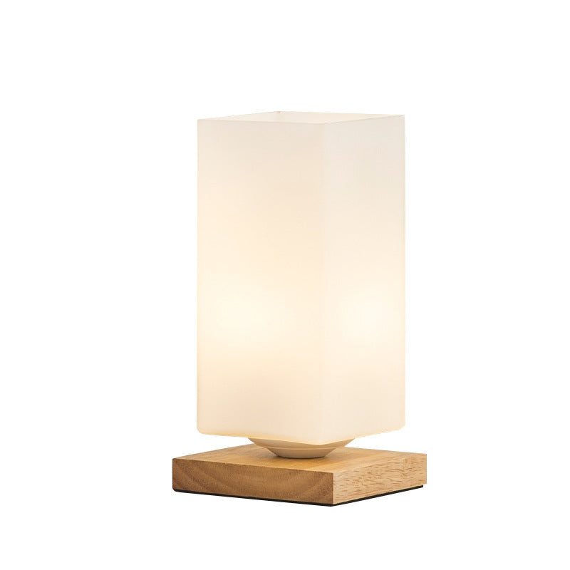 Solid wood table lamp with Nordic minimalist design, shown on a desk with warm ambient lighting