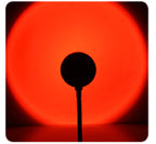 Sunset Projection Lamp casting a warm rainbow gradient light across a dark room, creating a cozy ambient mood lighting effect