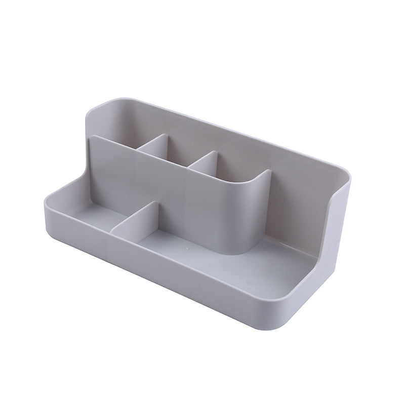Clear desktop makeup organizer with 5 compartments holding brushes, lipsticks, and skincare products on a vanity surface