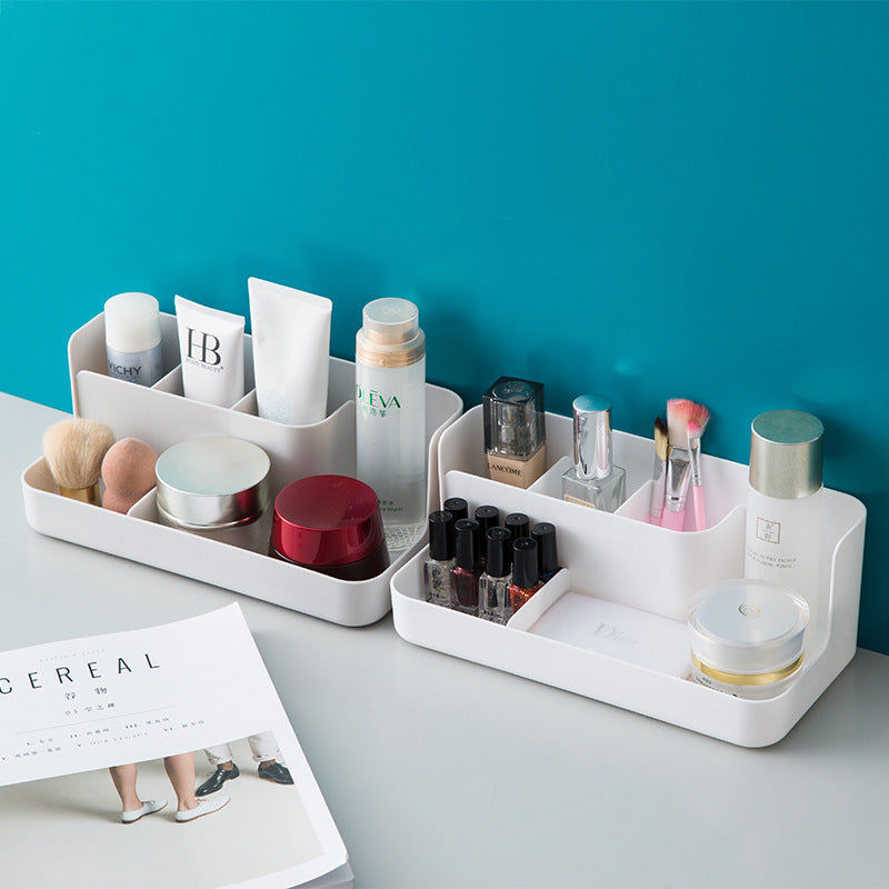 Clear desktop makeup organizer with 5 compartments holding brushes, lipsticks, and skincare products on a vanity
