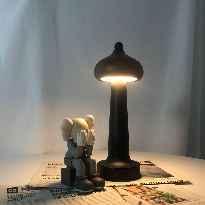 Modern minimalist LED USB table lamp glowing softly on a desk, offering warm ambient lighting for bedroom or home office deco