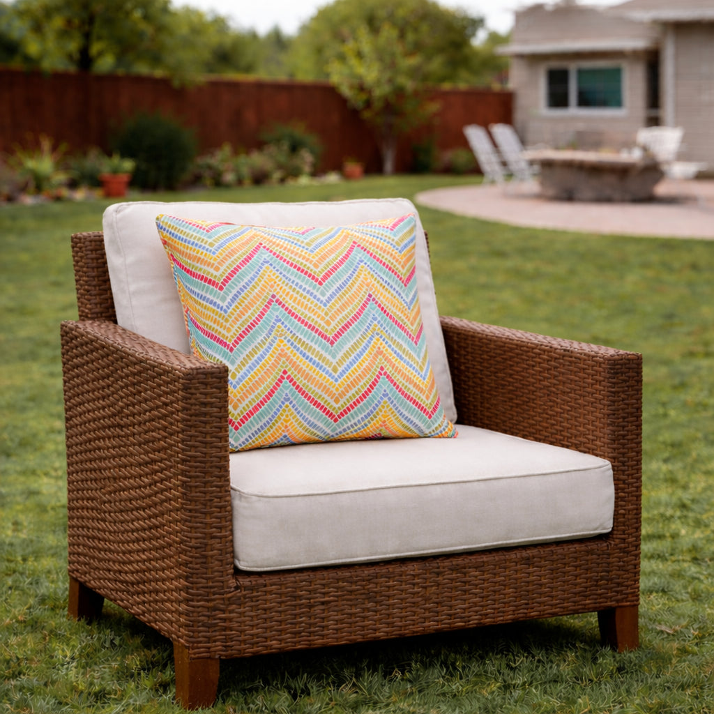 Two 18x18 waterproof outdoor throw pillows in neutral tones, shown on a patio chair for outdoor decor inspiration