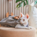 Sphynx cat wearing a soft knit bow dress in a cozy cat costume for hairless breeds