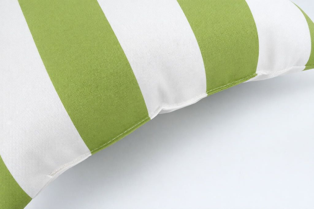 Two 18x18 green and white waterproof outdoor throw pillows displayed on a patio setting