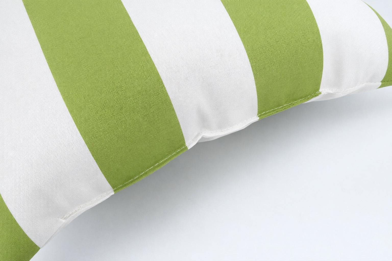 Two 18x18 green and white waterproof outdoor throw pillows displayed on a patio setting