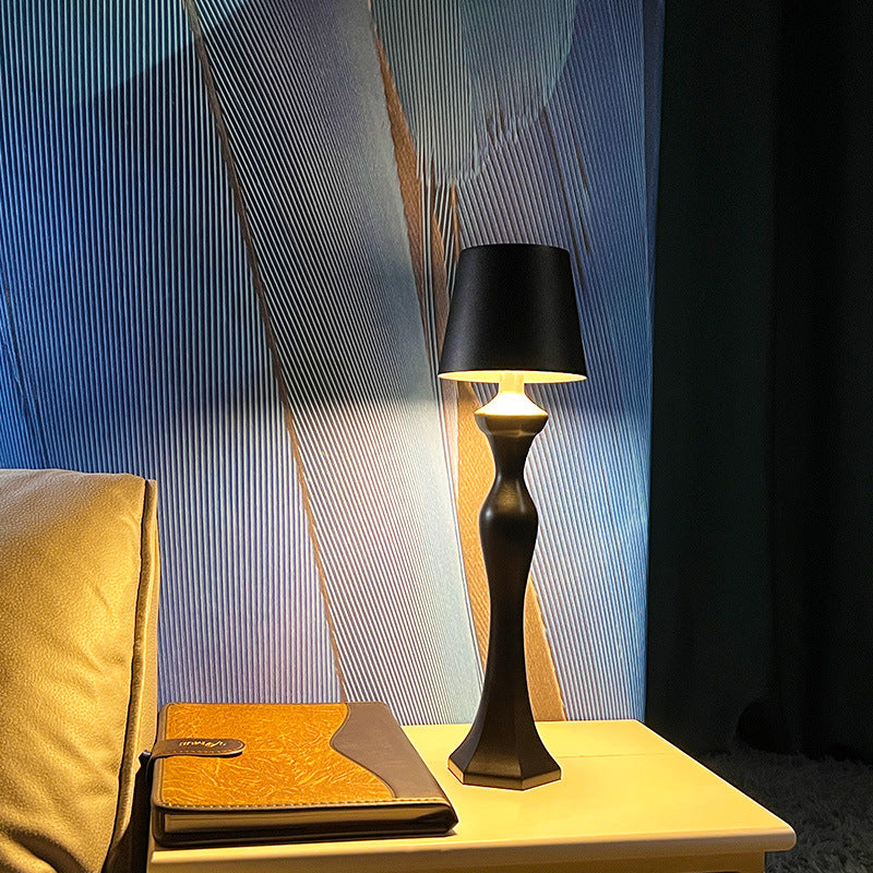 Warm light table lamp casting a soft amber glow on a bedside table, ideal for bedroom ambiance and nighttime decor.