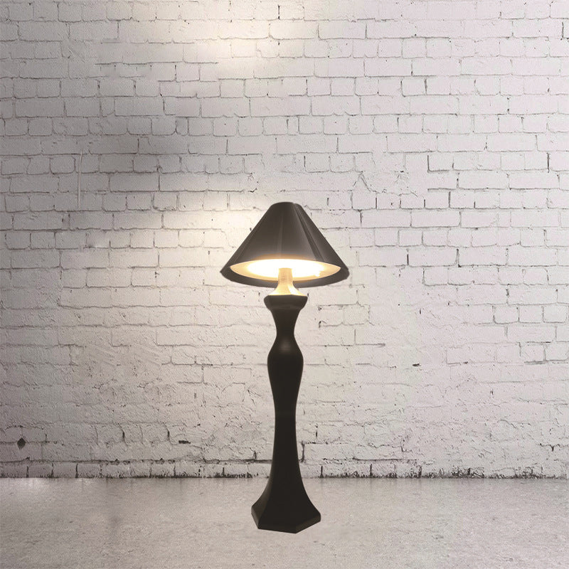Minimalist LED desk lamp with built-in charging pad glowing softly on a modern bedroom nightstand