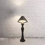 Minimalist LED desk lamp with built-in charging pad glowing softly on a modern bedroom nightstand