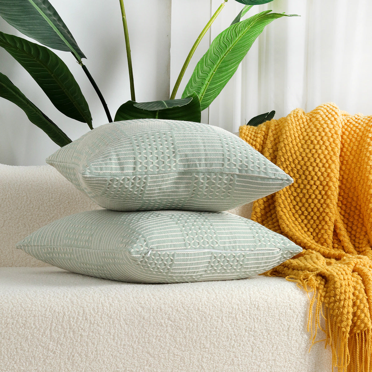 Close-up of a geometric jacquard cotton pillow cover showing textured woven pattern detail in neutral tones