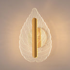 Modern minimalist leaf wall sconce glowing with warm tri-color LED light mounted on an interior wall