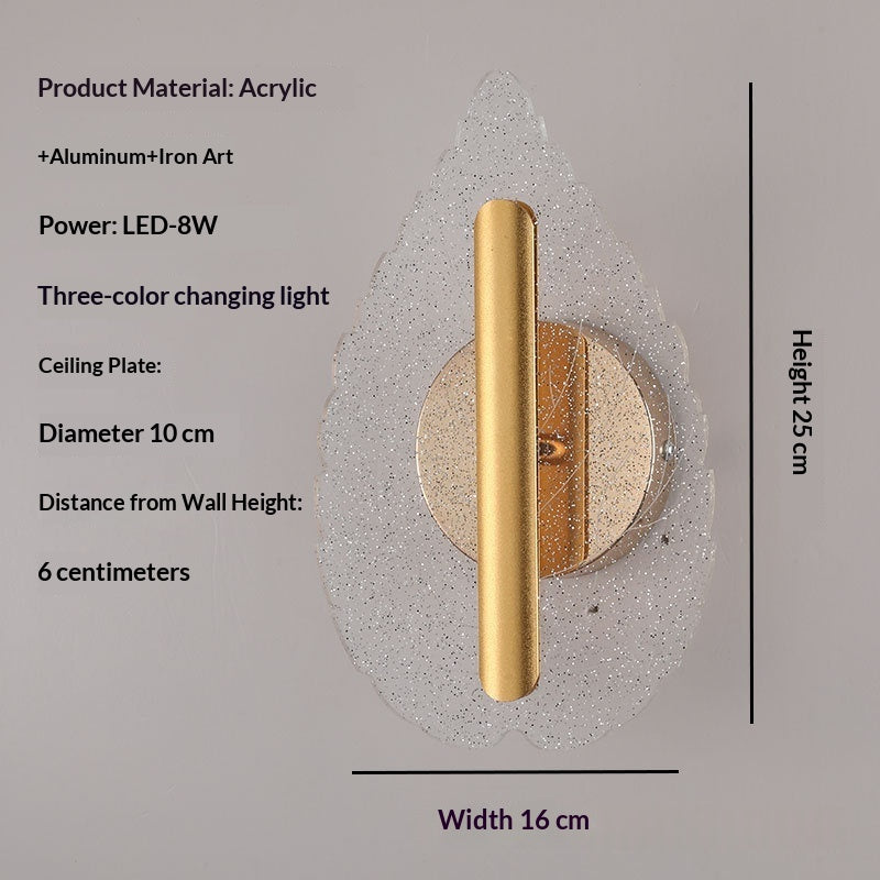 Modern minimalist leaf-shaped wall sconce glowing with warm tri-color LED light mounted on an interior wall