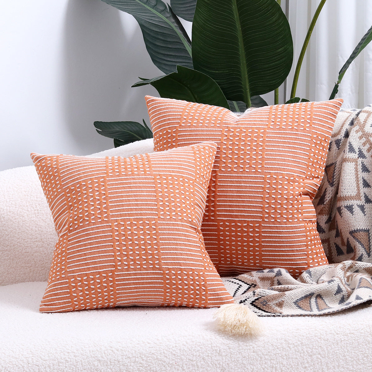 Close-up of a geometric jacquard cotton pillow cover showing textured woven pattern detail in neutral tones