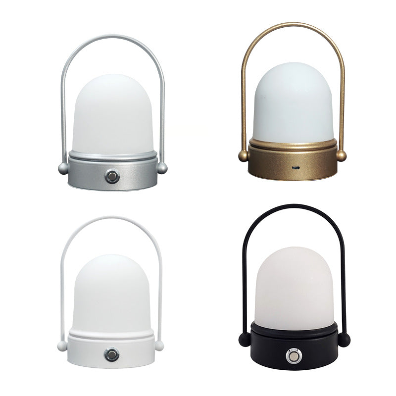 Rechargeable LED atmosphere night light with modern minimalist design, casting a soft warm glow on a bedside table