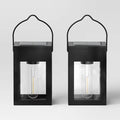 Matte black solar LED lantern path lights set of 2 placed along an outdoor garden walkway