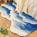 Fluffy wave-shaped bath mat in soft absorbent fabric, shown flat on bathroom floor with non-slip backing visible